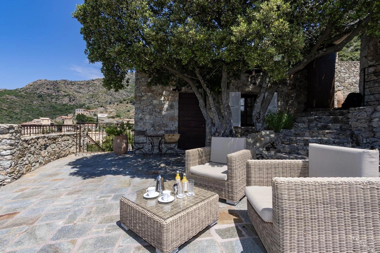 La terrasse ensoleillée des chambres de l'hôtel Case Latine à Lama en Balagne